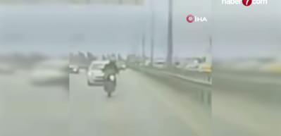 K&ouml;pr&uuml;den sarkan reklam afişi motosikletliyi yola savurdu