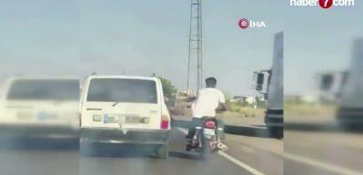 Şanlıurfa'da tehlikeli yolculuk: Motosiklet, otomobil kemerine tutunarak ilerledi