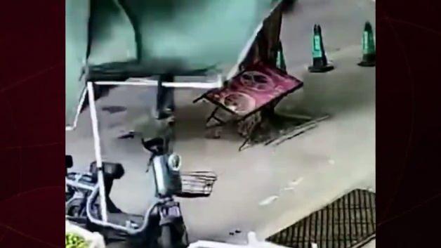 Çin'de tayfun sırasında bir kişinin tenteyle birlikte havada savrulduğu anın güvenlik kamerası görüntüsü.