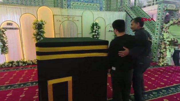 Zihinsel engelli genç Devlet Biberci'nin Kabe maketine sarılıp dua ettiği an.