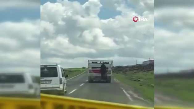Kamyonetin arkasına tutunarak yolculuk yapan kişi