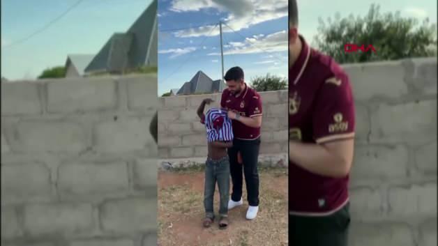 Tanzanya'daki bir köy okulunda Afrikalı çocuklar, Trabzonspor taraftarı Halis Mert Akyıldız'ın hediye ettiği bordo-mavili formaları giyip futbol topuyla oynuyor.