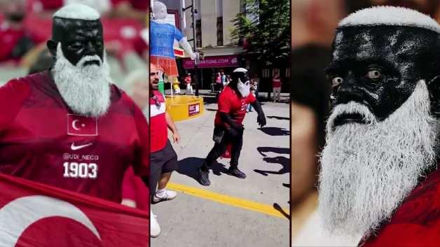 Necdet Ölçerman, Dünya Kupası maçında Türk bayrağı ve kendine has kostümüyle coşkulu bir şekilde milli takımı desteklerken görülüyor.