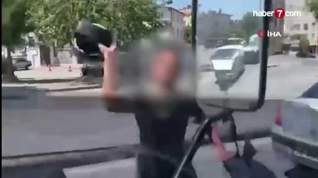 Motosikletli bir sürücünün trafikte tartıştığı bir aracın sürücüsüne kaskını fırlattığı anı gösteren temsili görsel.