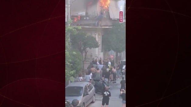 Yunanistan'da apartman yangınından kurtarılan yaşlı kadını vatandaşlar havada yakalıyor.