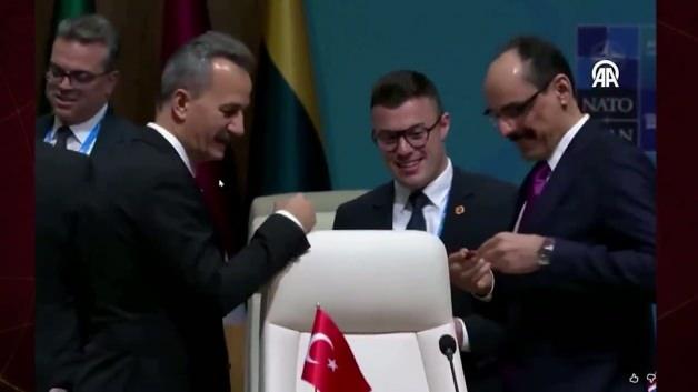 MİT Başkanı İbrahim Kalın'ın NATO Zirvesi'nde Cumhurbaşkanı Erdoğan'ın masasında bulunan kalemi incelemesi.
