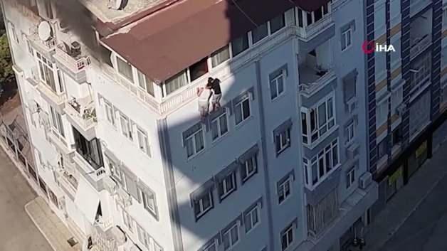 Antalya'da bir apartmanın teras katında çıkan yangında mahsur kalan iki kişi pencereden kurtarılıyor.