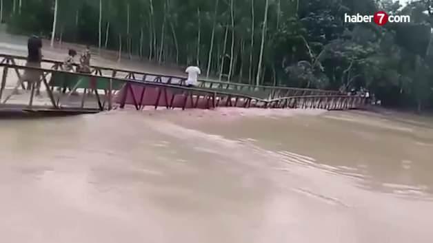 Bangladeş'te sel sularının yükselmesiyle çöken köprü ve suya kapılan insanlar.