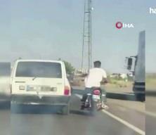 Şanlıurfa'da tehlikeli yolculuk: Motosiklet, otomobil kemerine tutunarak ilerledi