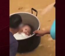 &Ccedil;in'de sel sularında mahsur kalan baba bebeğini tencereyle kurtardı
