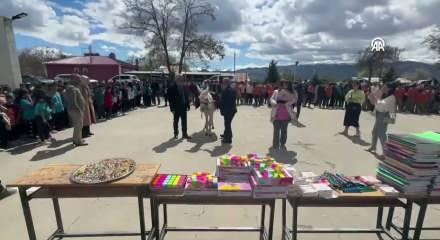 Almanya'dan Erzincan'a gelen gurbet&ccedil;i, eşek sırtındaki kitap ve kırtasiye malzemelerini &ouml;ğrencilere dağıttı