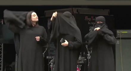 İngiltere'de infial yaratan g&ouml;r&uuml;nt&uuml;: Sahneye &ccedil;arşaflı &ccedil;ıkıp soyundular!