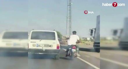 Şanlıurfa'da tehlikeli yolculuk: Motosiklet, otomobil kemerine tutunarak ilerledi