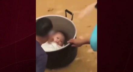 &Ccedil;in'de sel sularında mahsur kalan baba bebeğini tencereyle kurtardı
