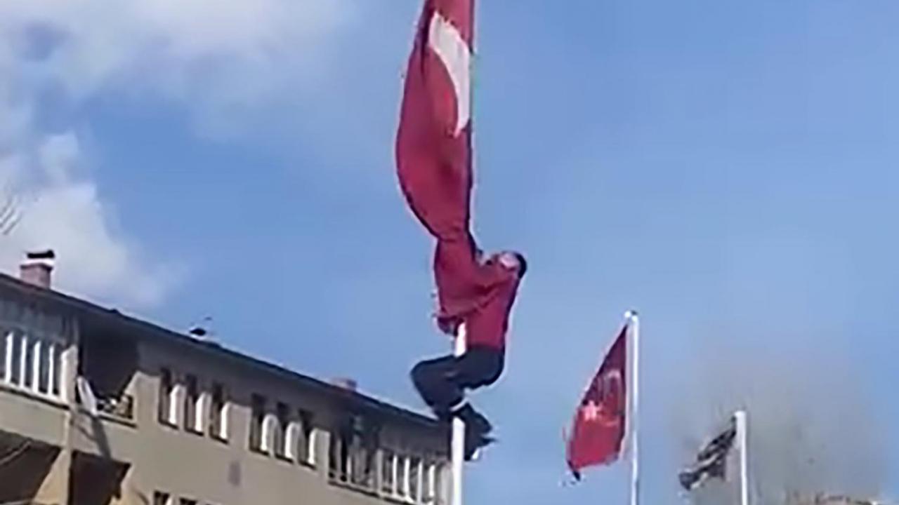 Rüzgârda dolanan bayrağı kurtarmak için 15 metrelik direğe tırmandı
