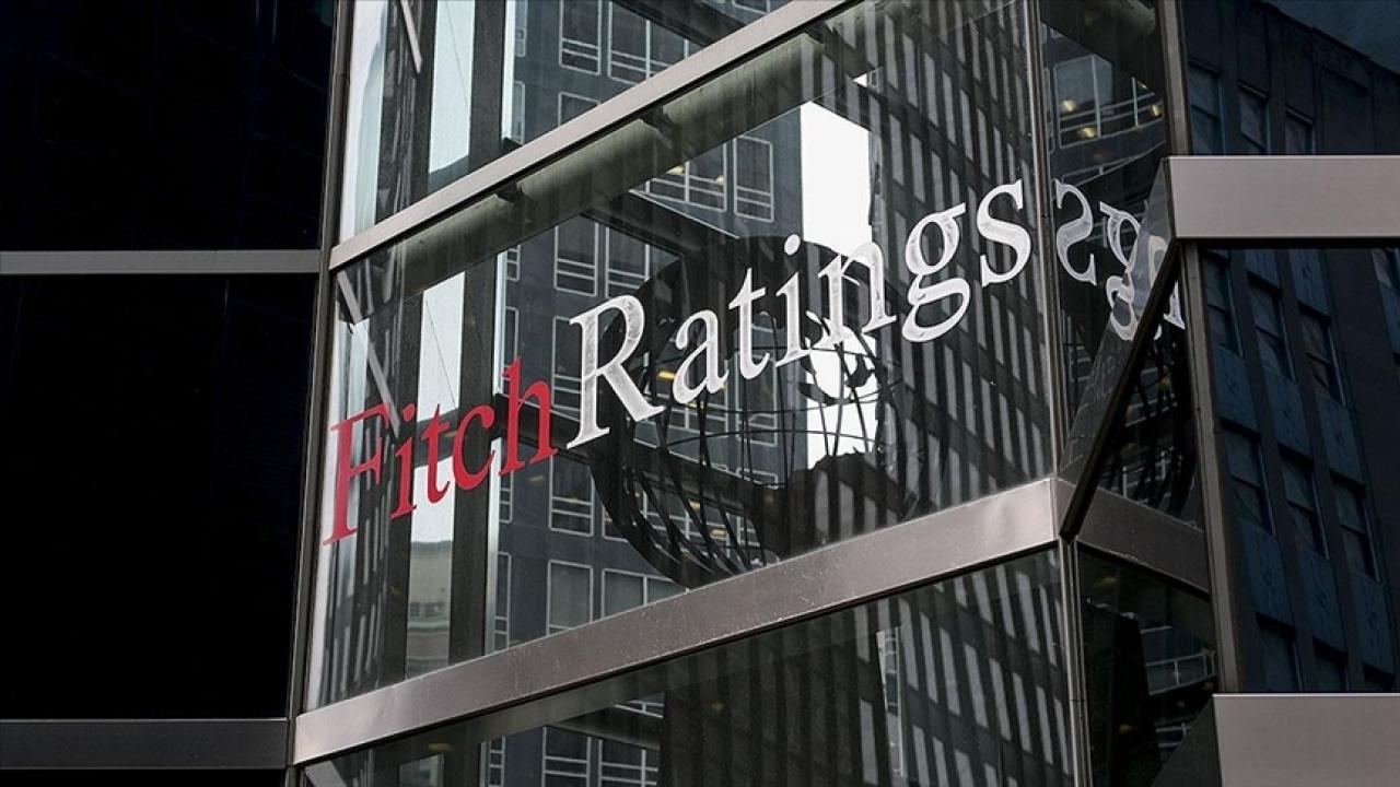 Uluslararası kredi derecelendirme kuruluşu Fitch Ratings logosu ve küresel ekonomi grafiklerini temsil eden soyut görsel.