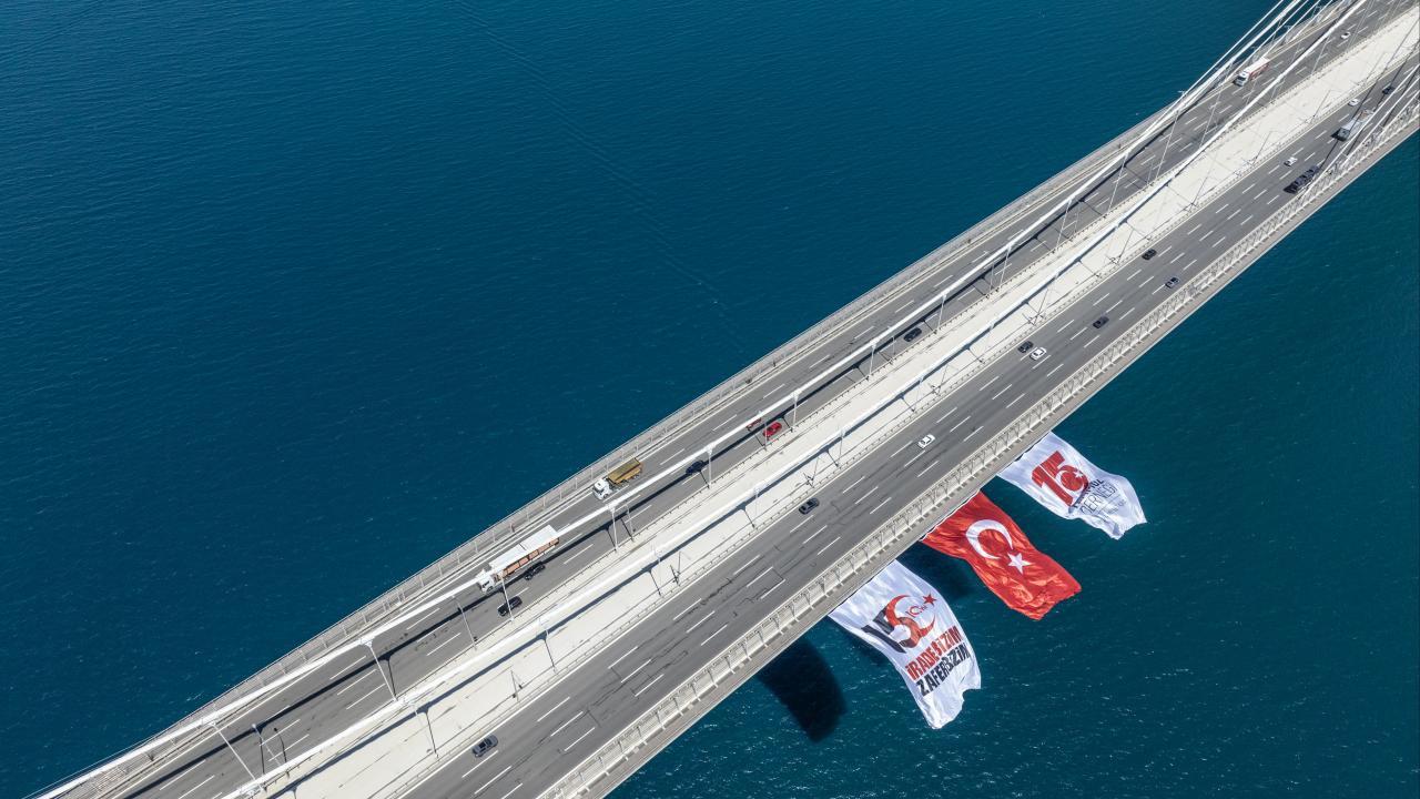 15 Temmuz Şehitler Köprüsü'ne asılan Türk bayrağı ve üzerinde 'İrade Bizim, Zafer Bizim' yazan afiş.