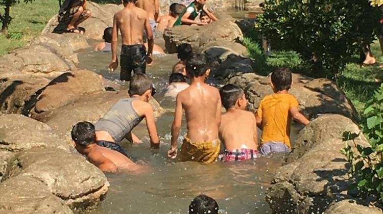 Sıcaktan bunalan çocuklar süs havuzunda serinliyor
