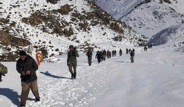 Karda yürüyen kaçakçılar tüfekleri ile yakalandı