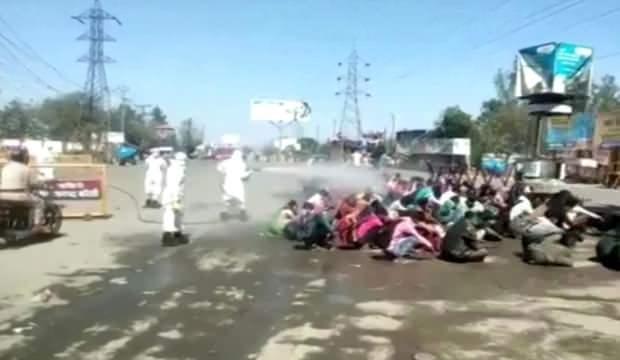 Hindistan'da göçmen işçiler, tazyikli suyla dezenfekte edildi