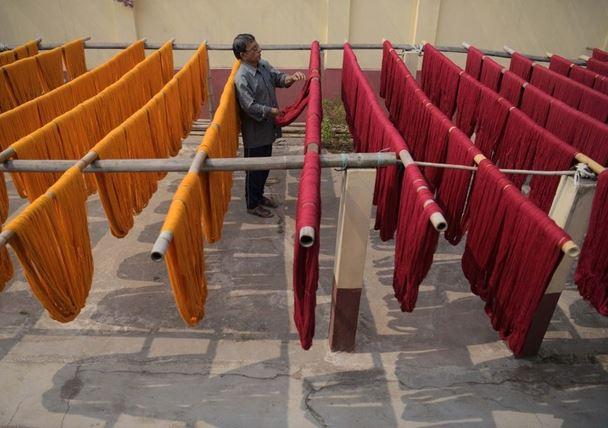 Hindistan'ın kuzeydoğusunda bulunan Tripura eyaletinin başkenti Agartala'daki bir fabrikada iplikleri kurutan bir işçi