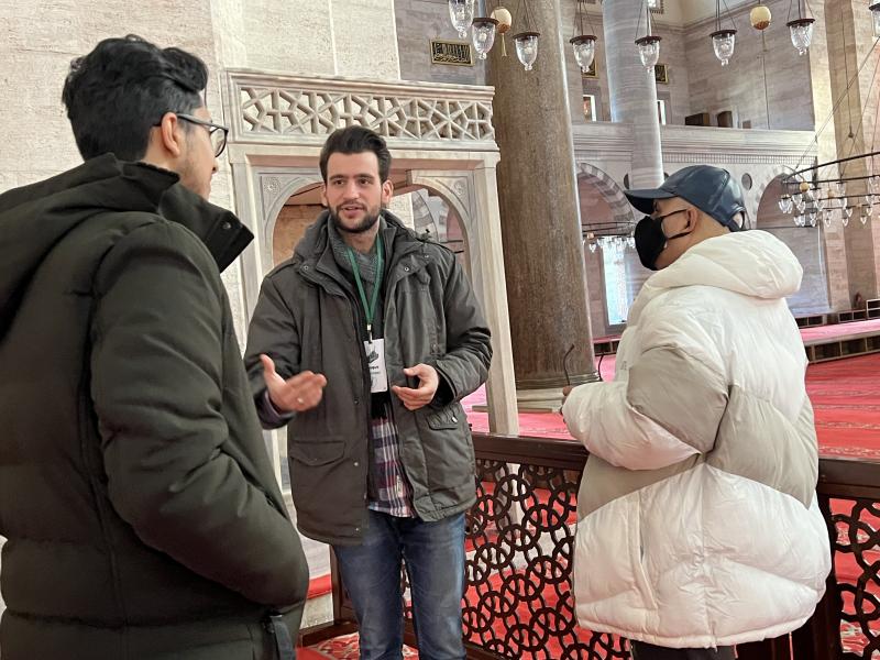 Fatih Ciner, camiye gelen turistlere tanıtım yapıyor
