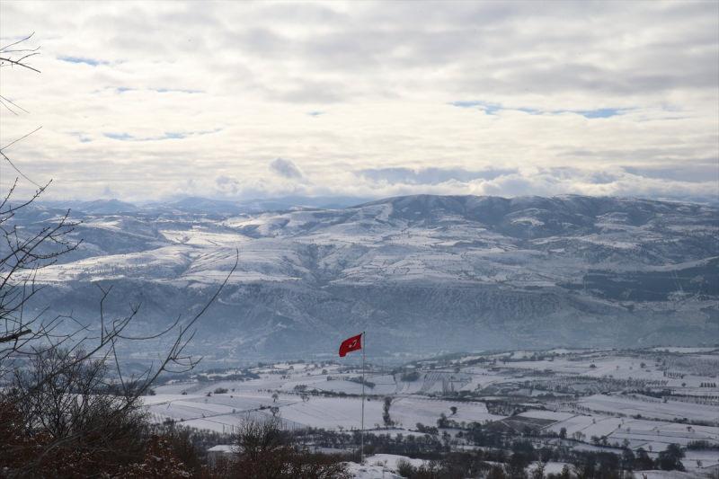 Karla kaplanan ova, arkasında sıra dağlar ve Türk Bayrağı... Tokat'ta kartpostallık görüntü.