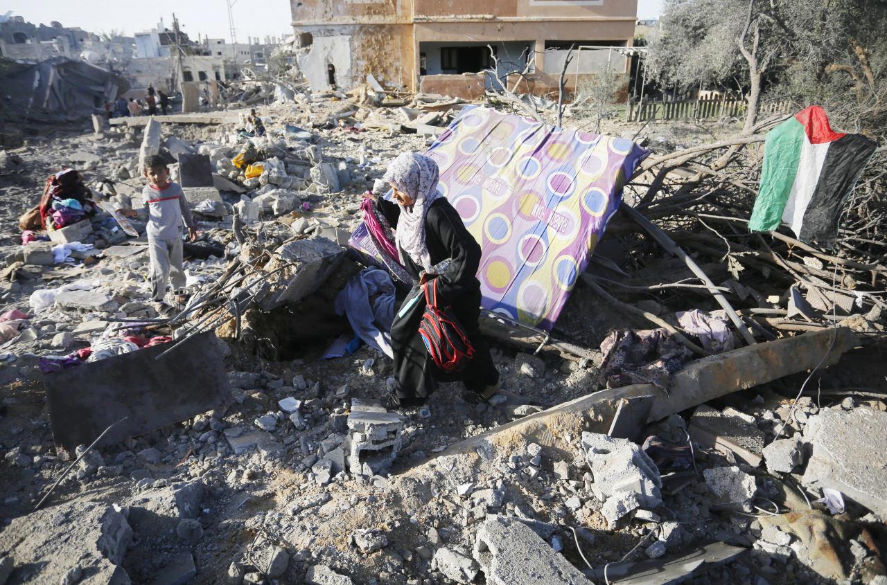 Bazı Filistinliler, İsrail saldırıları nedeniyle harabeye dönen evlerinin enkazları arasında kullanılabilir durumdaki eşyaları topladı..