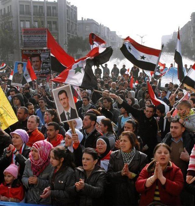 Suriye halkının sokaklarda ellerinde bayrak ve Beşşar Esad resimleriyle gösteri yapıyor