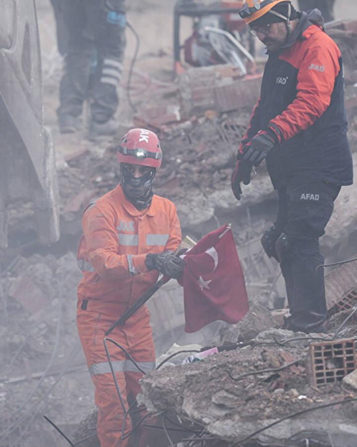 Ekiplerin bulduğu Türk bayrağını enkazdan çıkardığı anlar