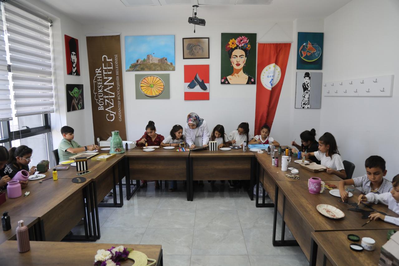 Yaz okuluna katılan çocuklar, el becerilerini geliştirecek etkinlikler yapıyorlar. 