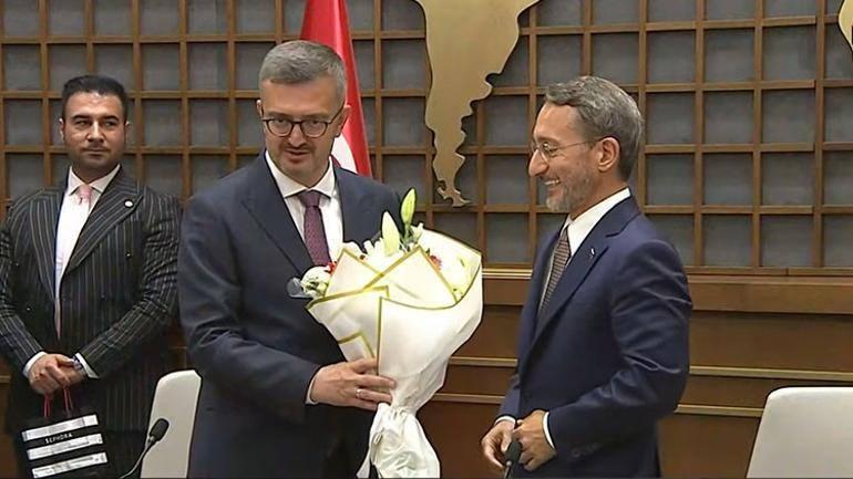 Fahrettin Altun (Sağda), Burhanettin Duran'a devir teslim töreninde çiçek hediye etti