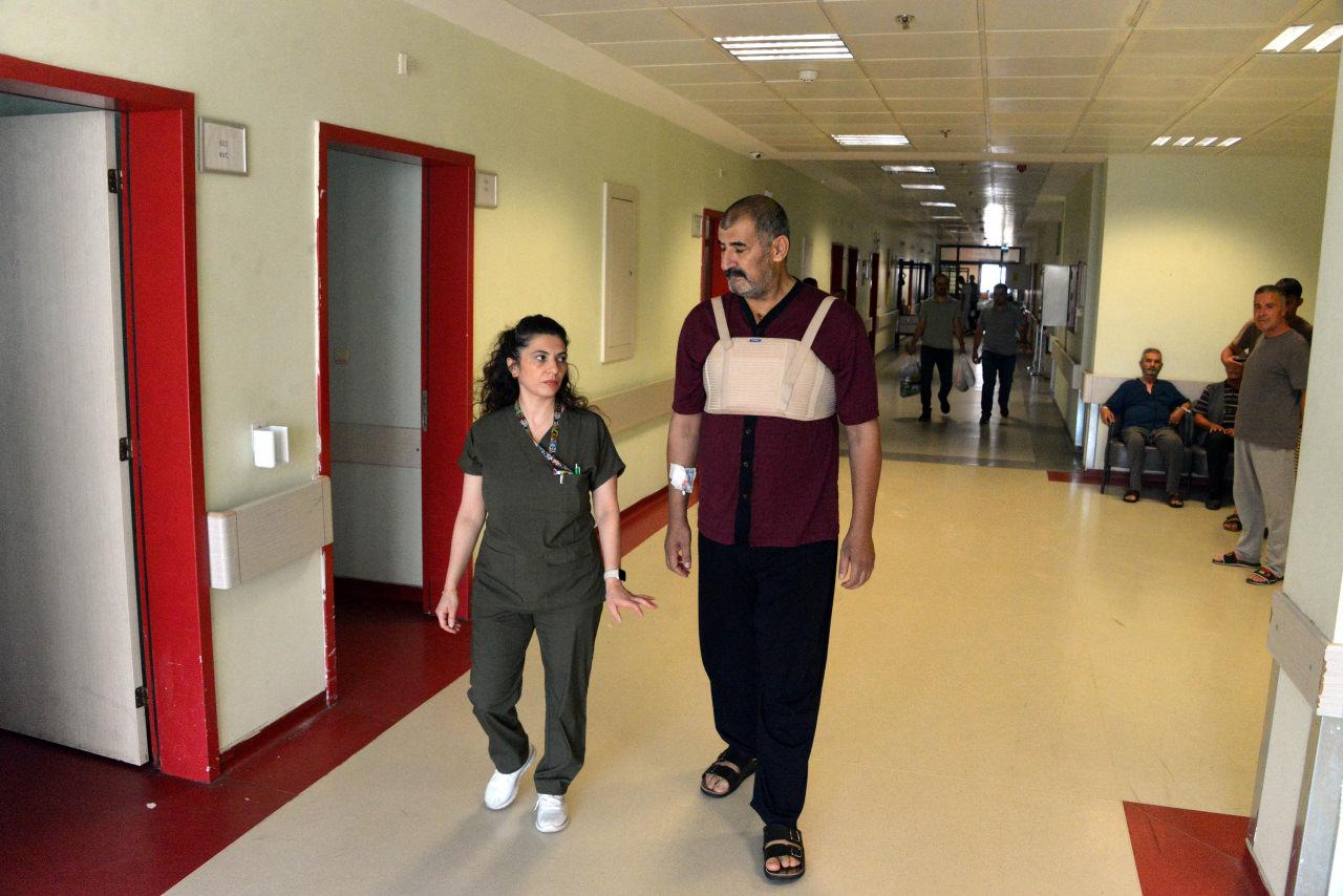 Aziz Karabörk ameliyat sonrası hastane koridorunda yürüyüş yapıyor.