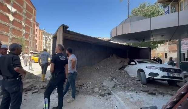 Hafriyat boşaltan kamyon, park halindeki otomobilin üstüne devrildi
