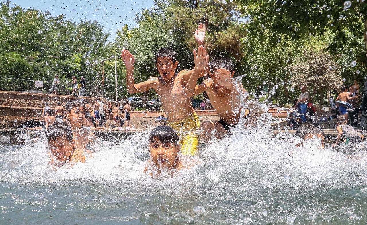 Sıcaktan bunalan çocuklar, süs havuzuna girdi. 