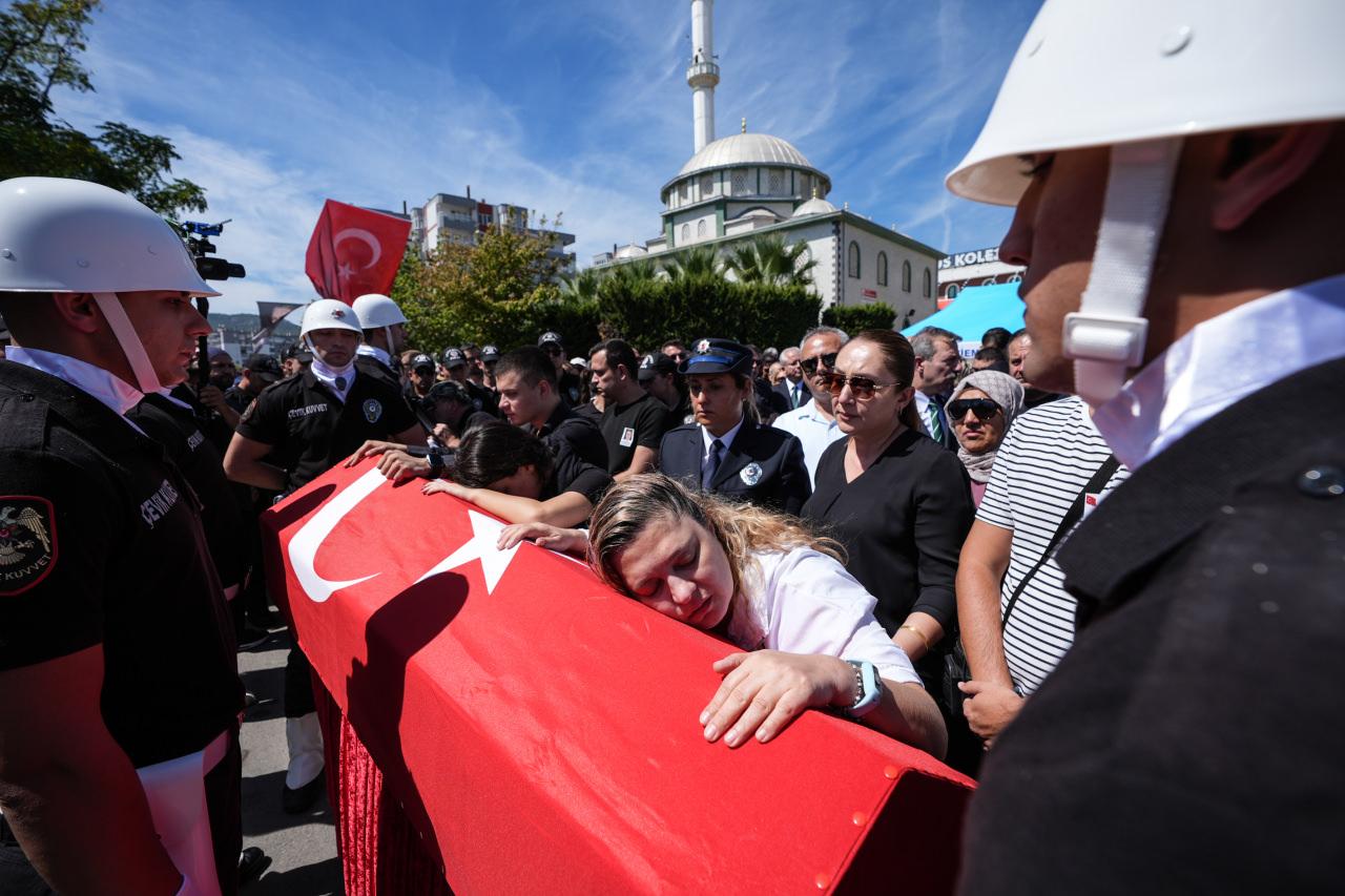 Törende, Muhsin Aydemir'in eşi Ebru Aydemir (sağda) ile çocukları Leyla ve Mert Aydemir, şehidin Türk bayrağına sarılı tabutuna sarıldı.