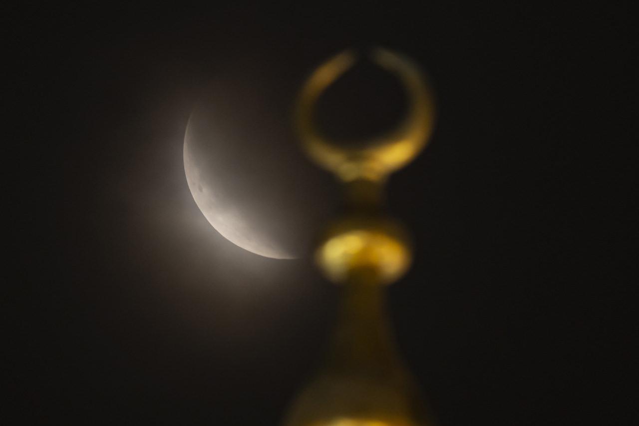 Kırmızı renginden dolayı 'Kanlı ay' olarak da bilinen dolunay, tutulma sırasında İstanbul'da Yeni Cami minarelerindeki alemler ile görüntülendi.