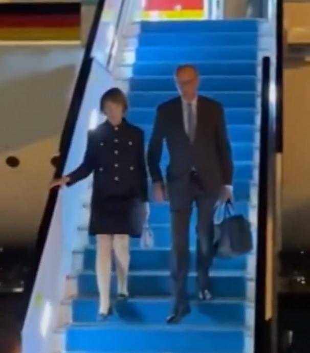 Merz Türkiye'de uçaktan inerken valizini taşıyor