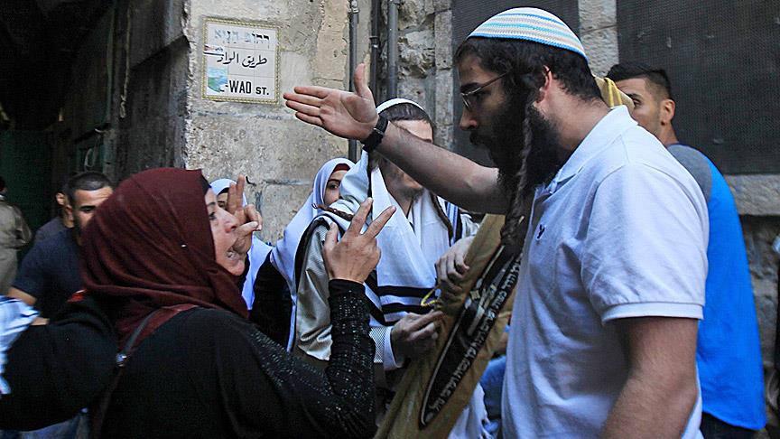 İsrailli yerleşimciler Filistinli kadına bağırırıken