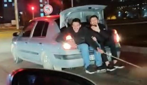 Bagaja oturup arızalanan arabayı elleriyle tuttukları iple &ccedil;ektiler