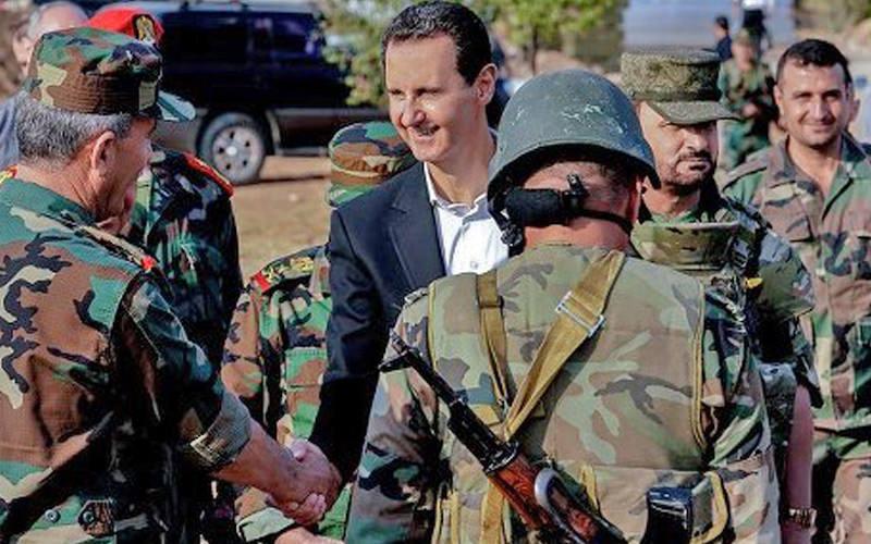 Suriye'nin devrik lideri Beşar Esed, askerlerle birlikteyken çekilmiş bir fotoğraf.