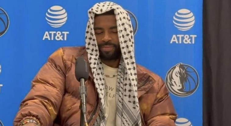 Kyrie Irving, bir basın toplantısında kefiye ile oturuyor.