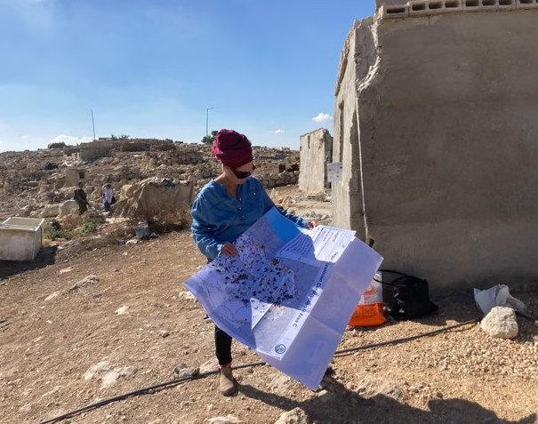 Sözde hayır kurumu Regavim üyesi elinde harita tutarak Batı Şeria'daki bir köyde inceleme yapıyor. (Kaynak: The Guardian)