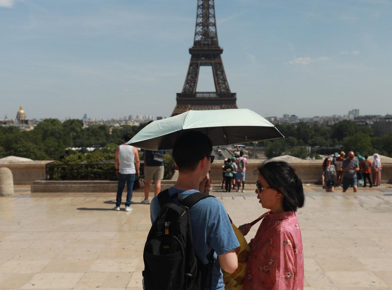 Fransa'nın başkenti Paris'te, Avrupa'yı etkisi altına alan aşırı sıcak hava dalgası nedeniyle şehri ziyaret eden turistler, şemsiyelerle güneşten korunmaya çalıştı.