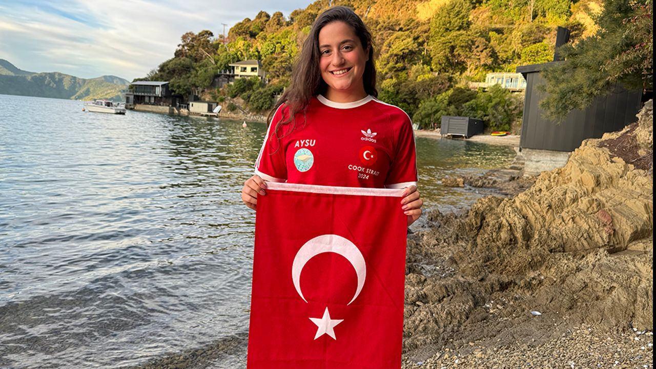 Milli yüzücü Aysu Türkoğlu Tsugaru Kanalı'nı geçerken bayrak sallıyor.