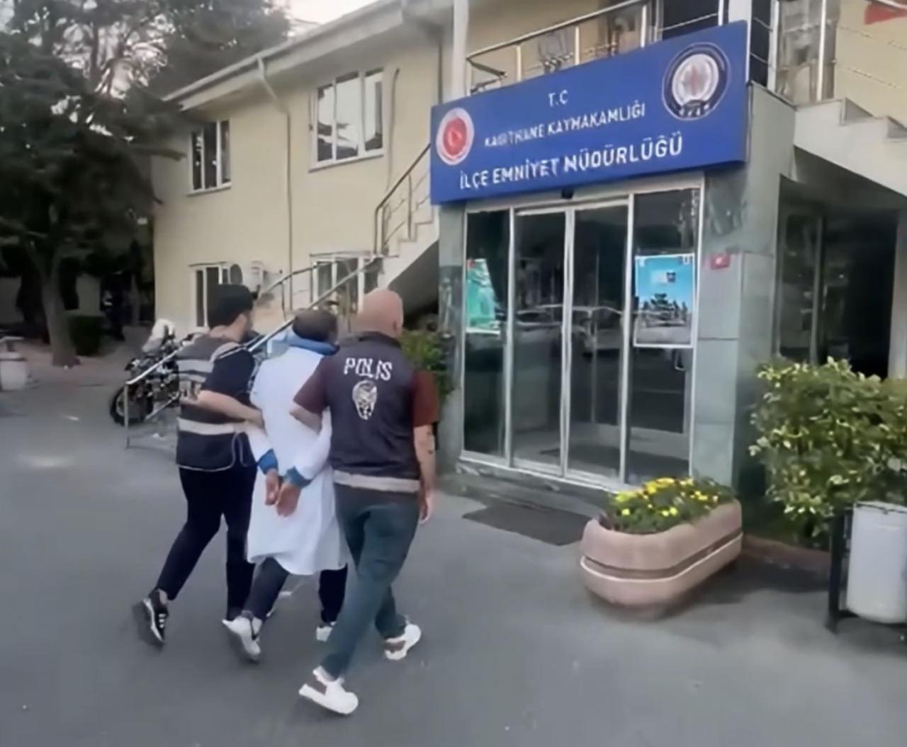 Türk bayrağını yere atan şüpheli Cafer B. polis tarafından gözaltına alınırken çekilmiş fotoğraf.