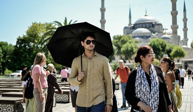 İstanbul'da sıcak hava etkili oldu: Turistler g&ouml;lge ve şemsiyeye sığındı