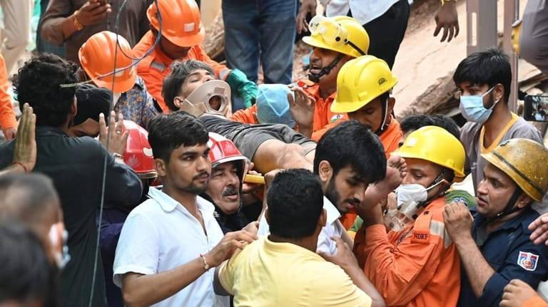 Hindistan'ın başkenti Yeni Delhi'de çöken yurt binasının enkazından bir öğrenci çıkarılıyor.