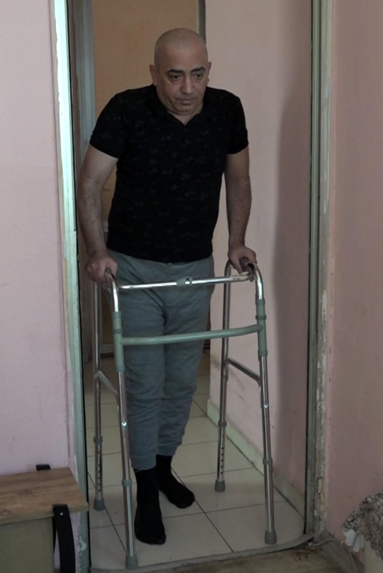  Serkan Özdemir (49), yürüteç desteğiyle yürümeye çalışıyor. 
