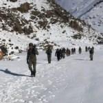 Karda yürüyen kaçakçılar tüfekleri ile yakalandı